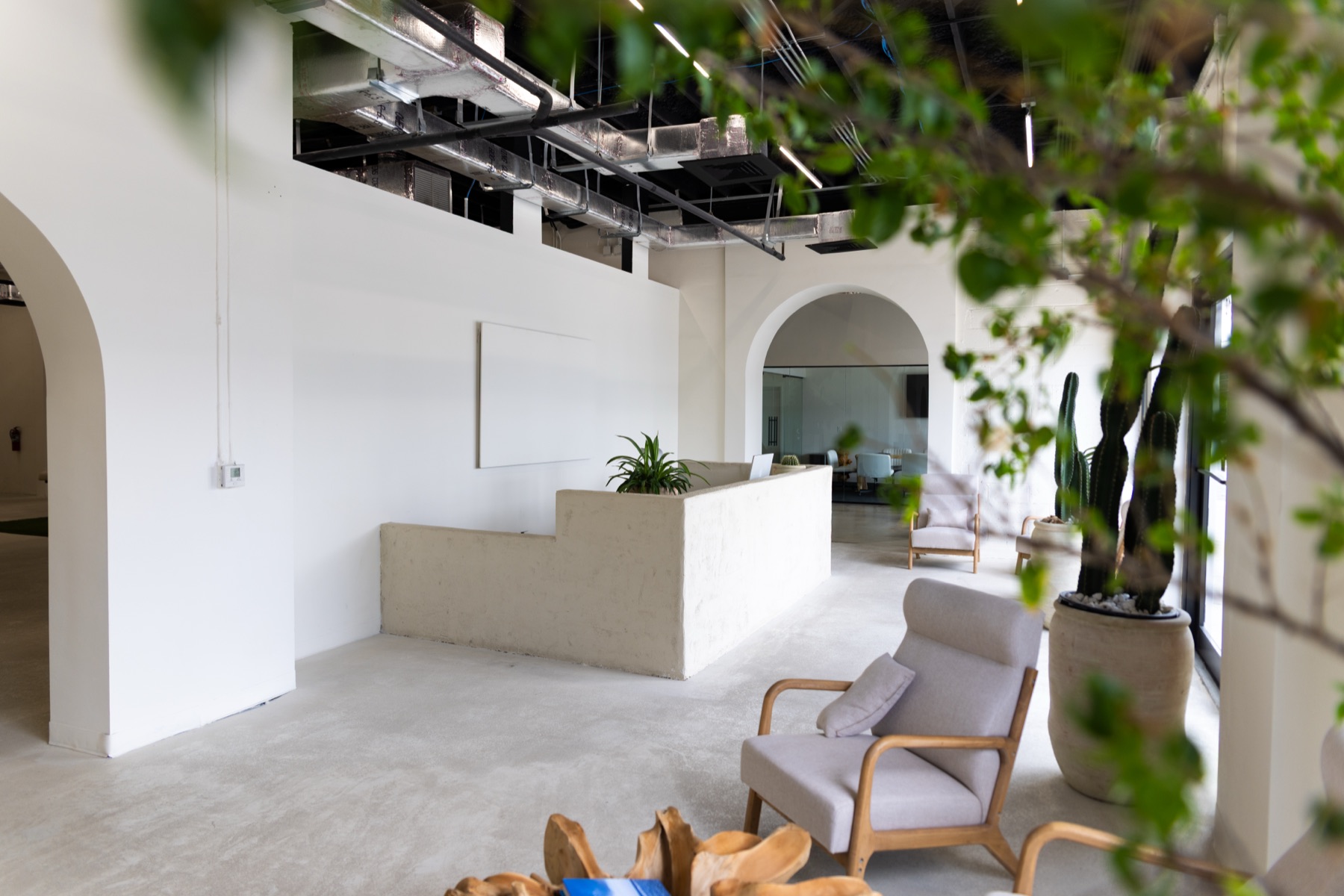 The Infinity Delta reception lounge with arched openings, soft seating, and greenery.